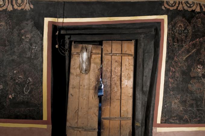 Much of the monastery was destroyed during the Cultural Revolution. The gönkhang, however, was converted into a monastery granary and saved. Years of neglect, and an instability in the building's foundation, however, took their toll on the temples elaborate murals. the main entrance to the Gönkhang at Galingteng